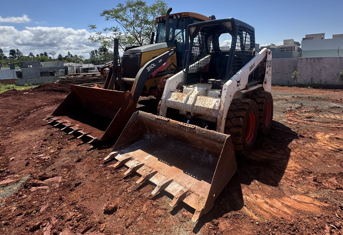 Minicarregadeira Bobcat e retroescavadeira da L2K em terreno de obra